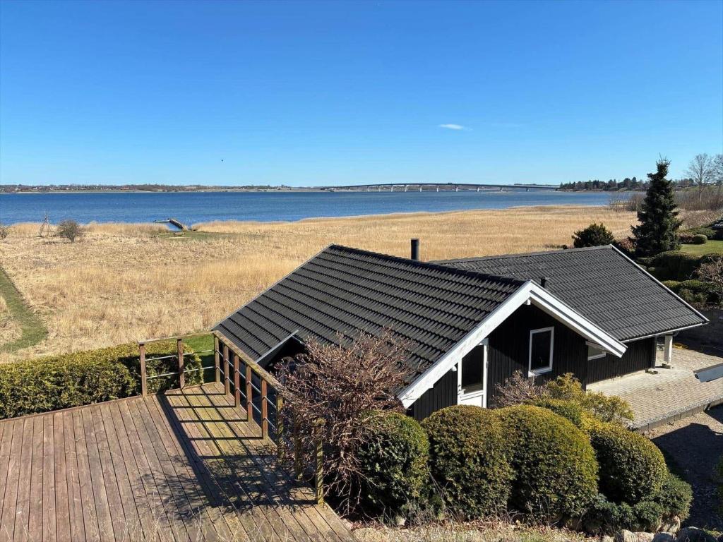 a house with a deck and a view of the water at FJ1602-Jaegerspris-Strandmarksvej-37 in Jægerspris