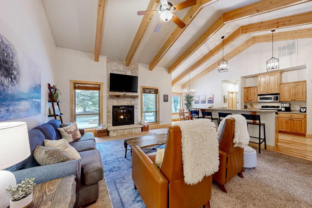 a living room with couches and a kitchen at Sunset Cabin in McCall