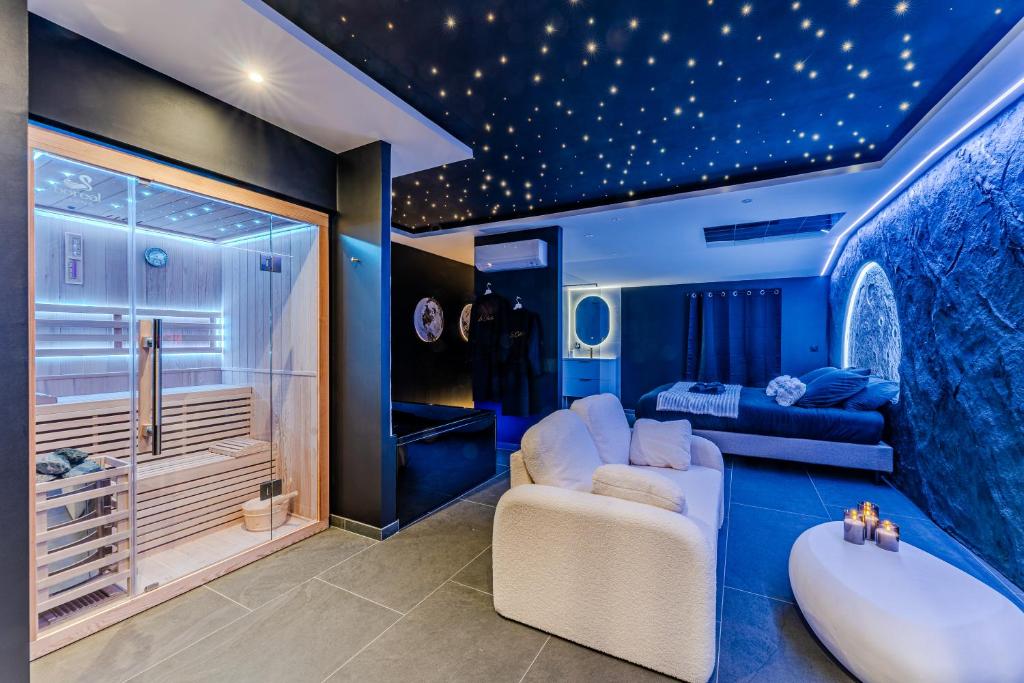 a blue room with a tub and a bedroom at Le Céleste - Suite romantique immersive climatisée, sauna et spa privatif in Lesparre-Médoc