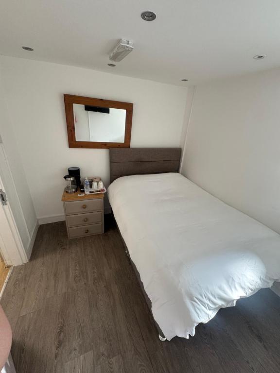 a bedroom with a large white bed and a mirror at The Dublin Packet Double Room Number 8 in Holyhead