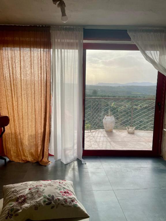a bedroom with a large window and a balcony at Ahiri traditional cottage in Galatás