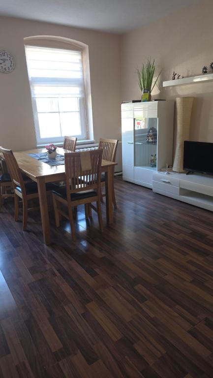 a living room with a wooden table and chairs at Ferienwohnung am Kanuverleih in Oderberg