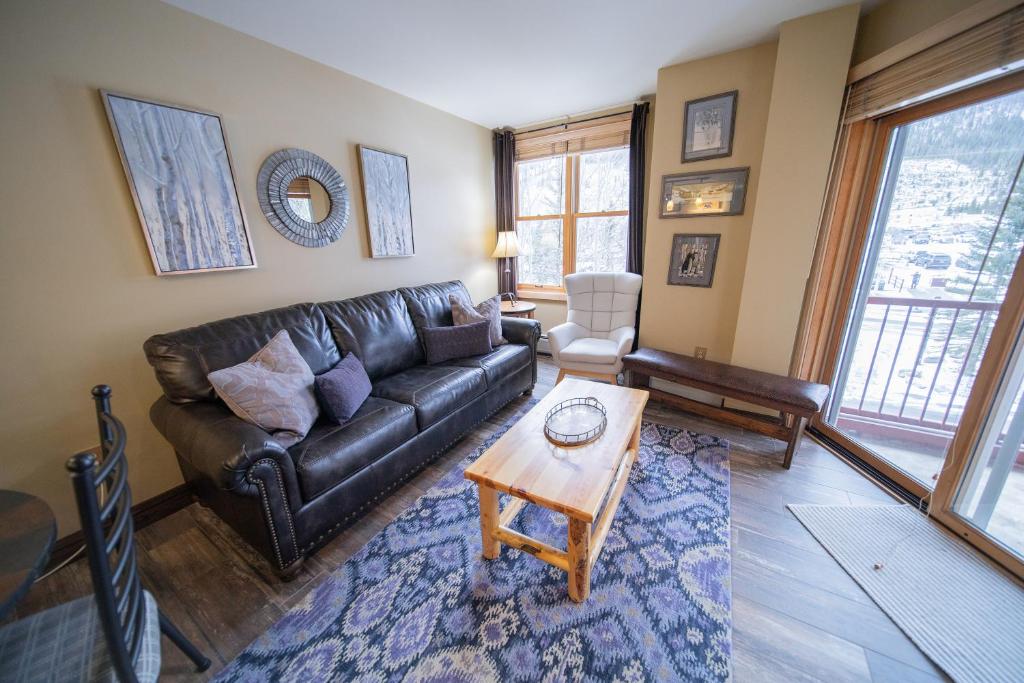 a living room with a leather couch and a table at Silver Mill 8228 by SummitCove Lodging in Colorado in Keystone