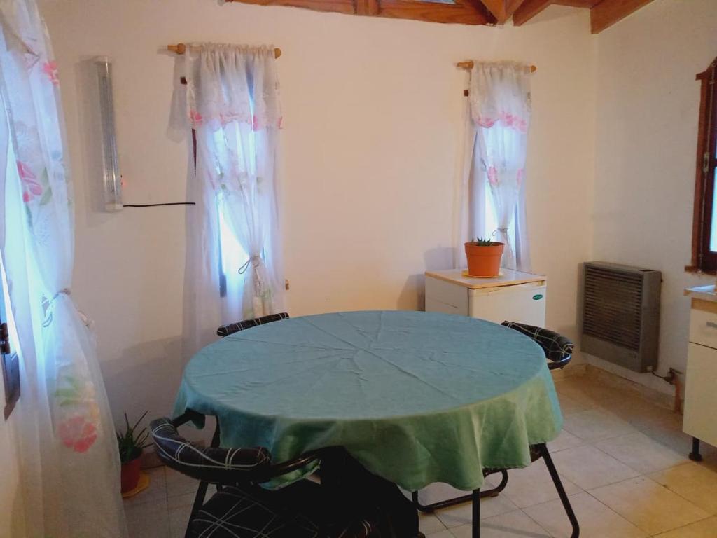 a kitchen with a table with a green table cloth at Departamento Los Ñires in Yacimiento Río Turbio