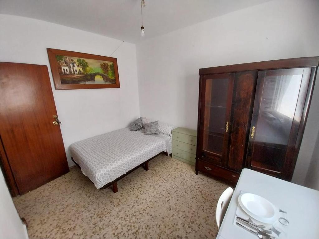 a bedroom with a bed and a cabinet and a sink at Habitación D doble economica in Cantillana