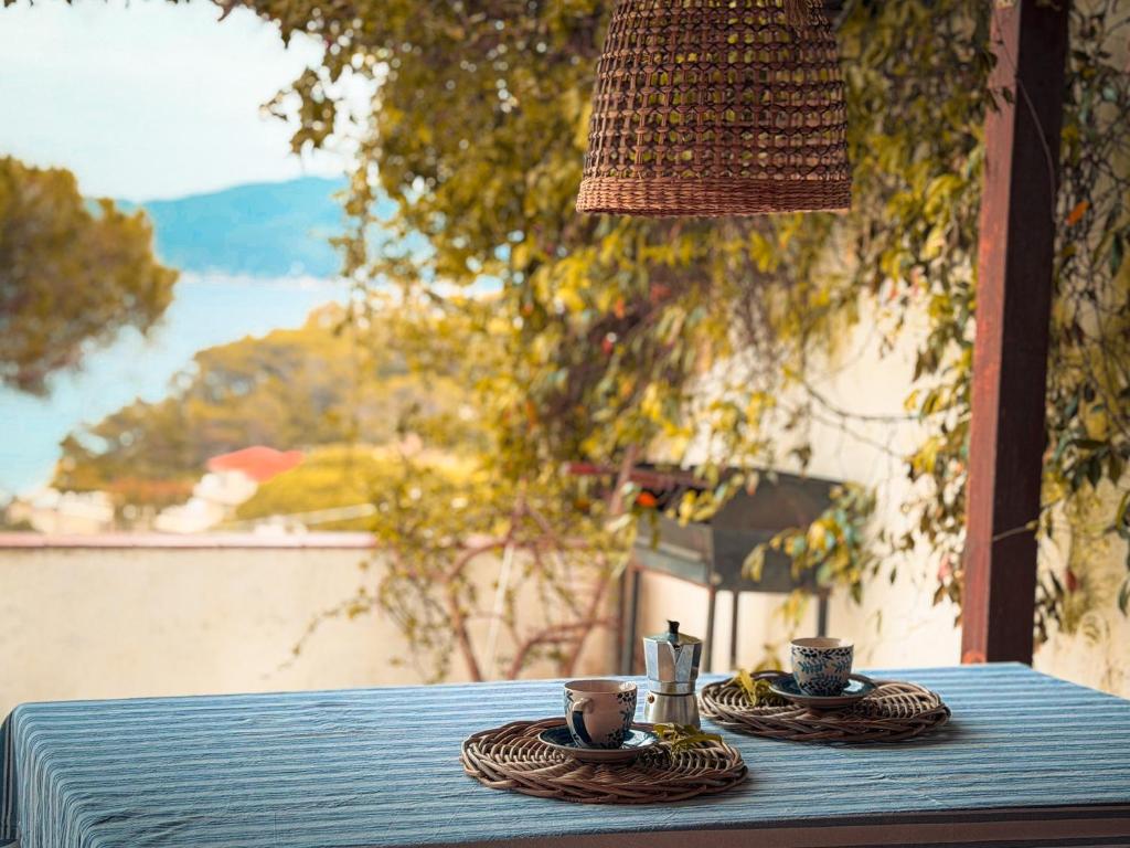 a table with two cups and saucers on it at Fuga d'Amore - HelloElba in Portoferraio