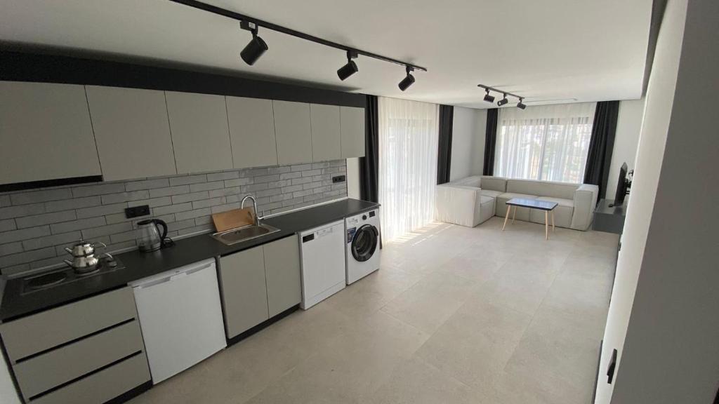 a large kitchen with a sink and a washing machine at Bodrum has apart otel in Bodrum City