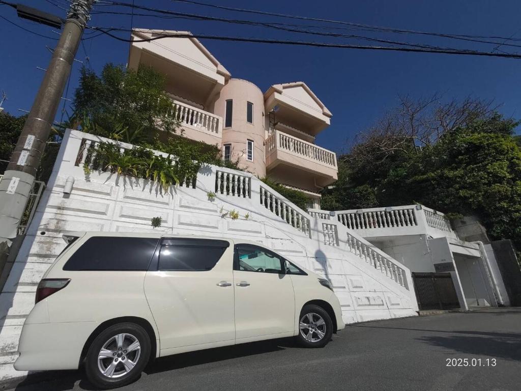 a white van parked in front of a building at Green Ocean Kingdom House in Uruma
