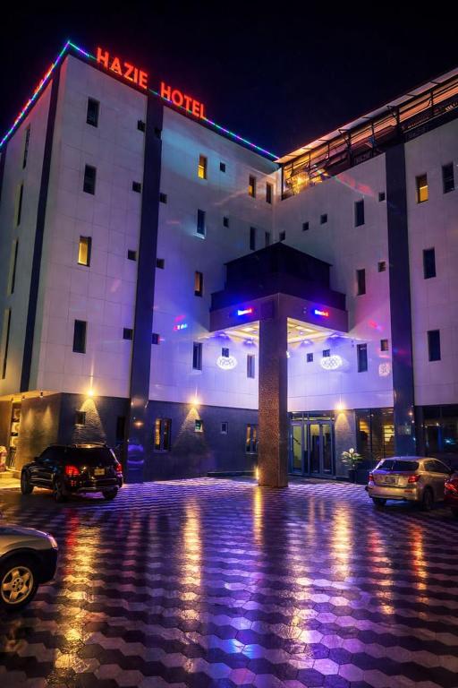 a hotel with cars parked in front of it at night at Hazie Hotel in Lagos