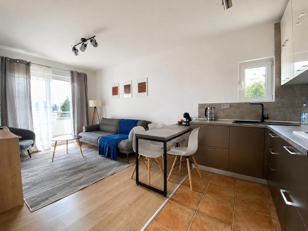 a kitchen and living room with a table and a couch at Comfort Apartment Becici in Bečići