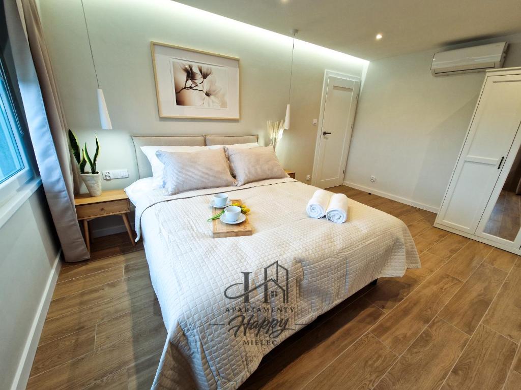 a bedroom with a bed with two towels on it at Happy Deluxe ApartamentyHappy pl in Mielec