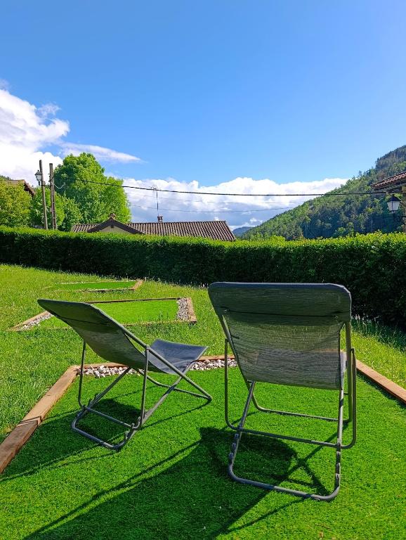 a green chair and a rake sitting on the grass at Iguzki Etxea in Urzainqui