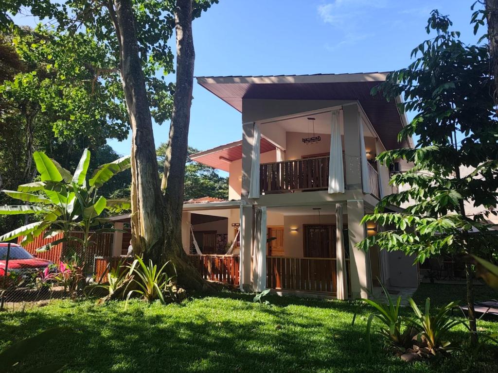 a house with a tree in front of it at Caribbean Lory in Puerto Viejo