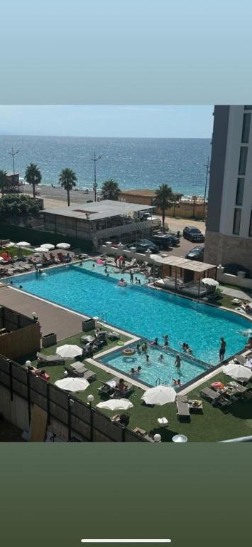 a large swimming pool with people in it next to the ocean at Green side in Kvariati
