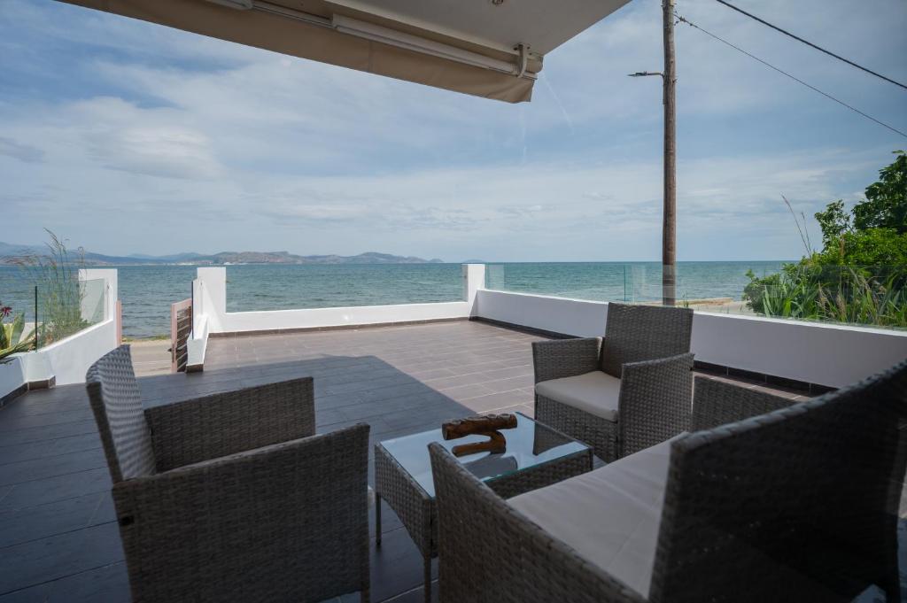 an outdoor dining area with a view of the ocean at Kalypso Rental Apartment in Myloi
