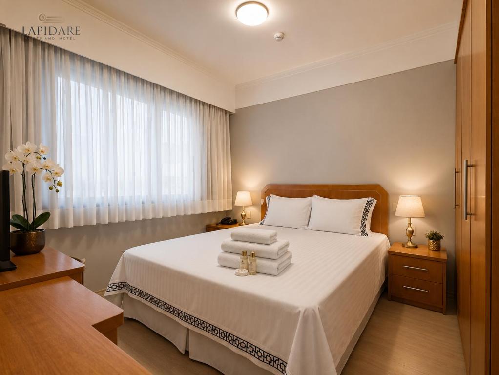 a bedroom with a bed with towels on it at Lapidare Flat Hotel Comfor Alphaville até 4 pessoas in Barueri