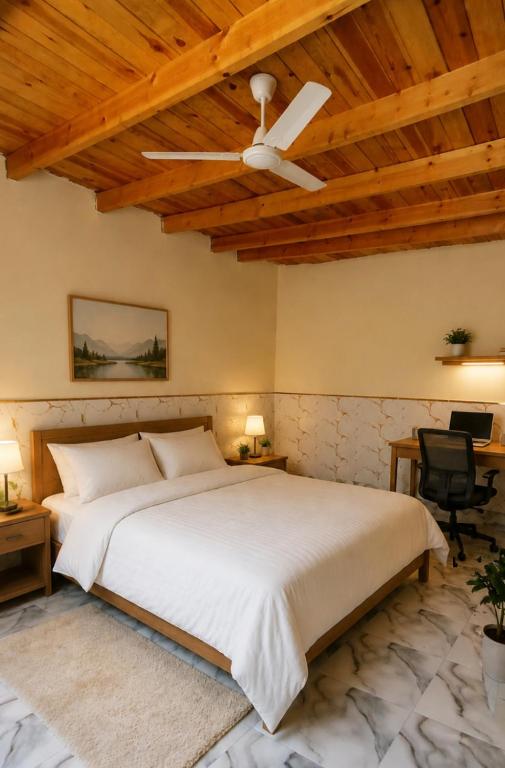 a bedroom with a large bed with a ceiling fan at Quiet Mini Villa with Garden in Luxor