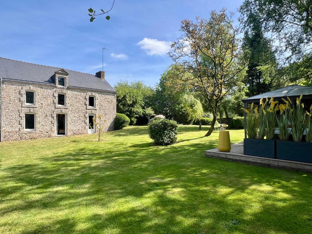 a house with a grass yard with a gazebo at L'Escale d'Armorique 1 in Languidic