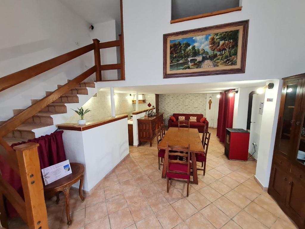 ein Wohnzimmer mit einem Tisch und einer Treppe in der Unterkunft Il Camerone in Isola del Liri