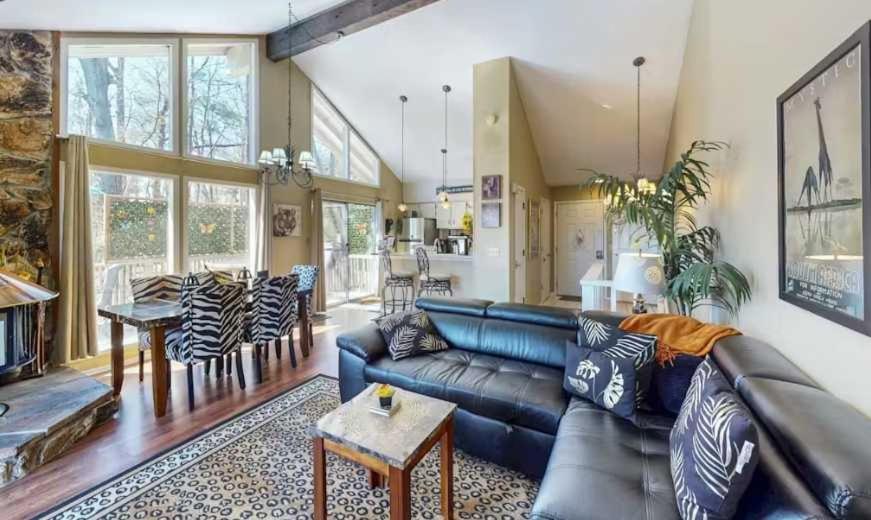 a living room with a leather couch and a table at The Safari Lodge in Osage Beach