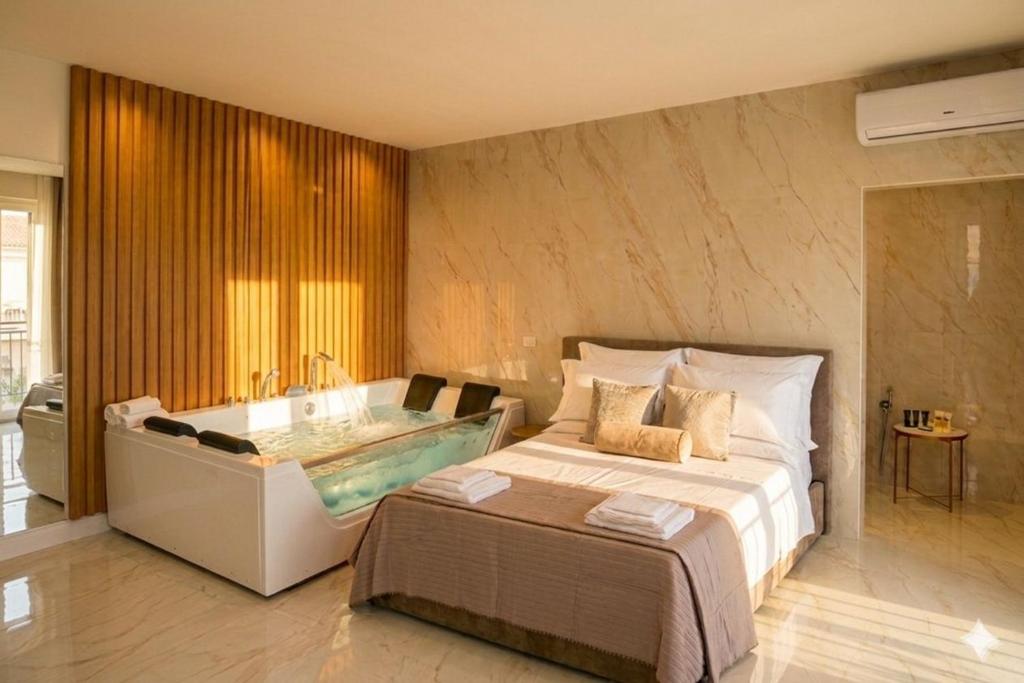 a bedroom with a bathtub and a bed and a bath tub at Partenopeo Rooms & Suite in Nola