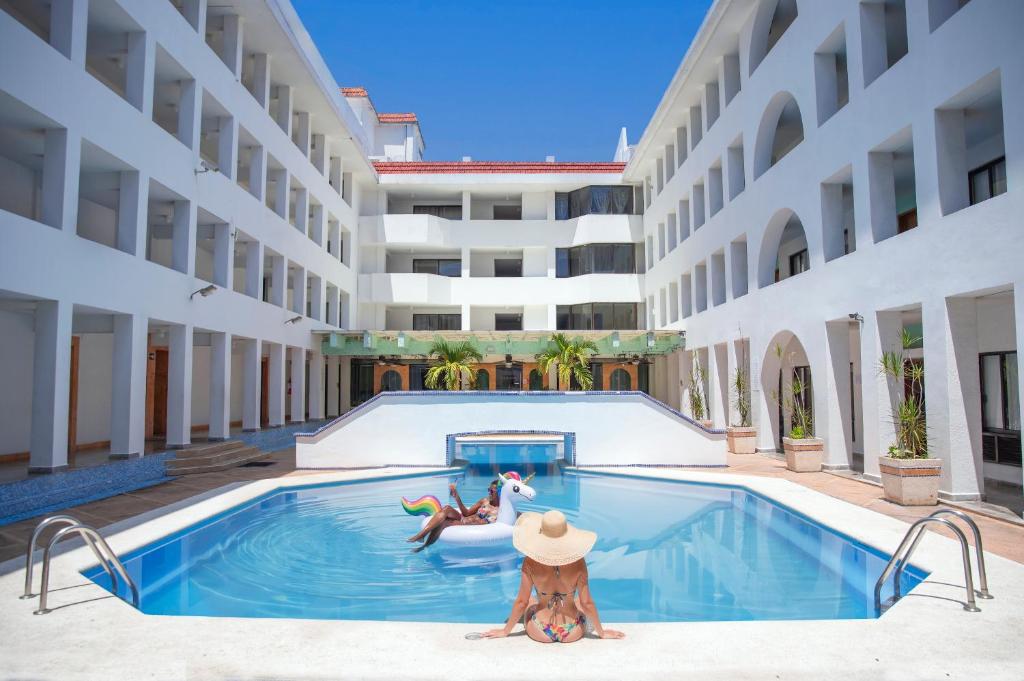 two people in a swimming pool in a building at Eurohotel in Ciudad del Carmen