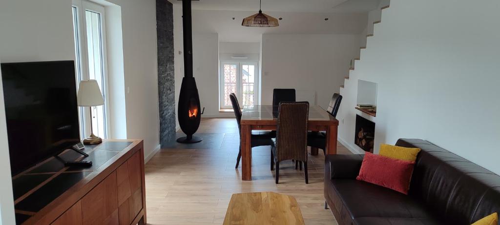 a living room with a table and a couch at Le Point Relais in Fumay