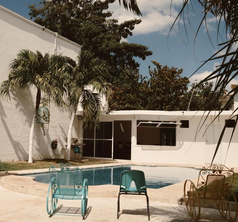 a swimming pool with chairs in front of a house at Casa Bedz, alberca privada in Campeche
