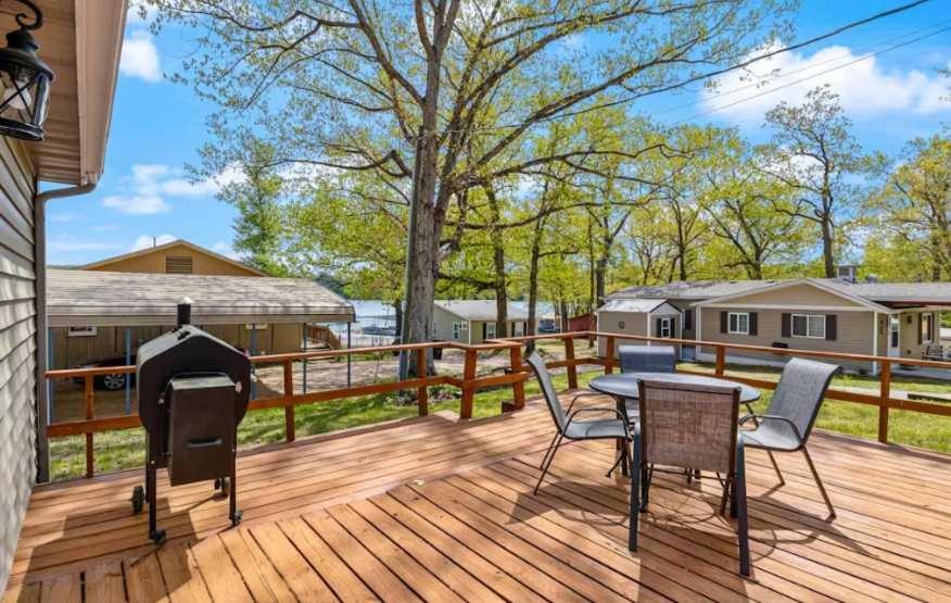 a deck with a grill and a table and chairs at Eternal Sunrises in Sunrise Beach