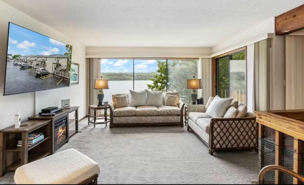 a living room with two couches and a flat screen tv at Pelican Bay Getaway in Lake Ozark
