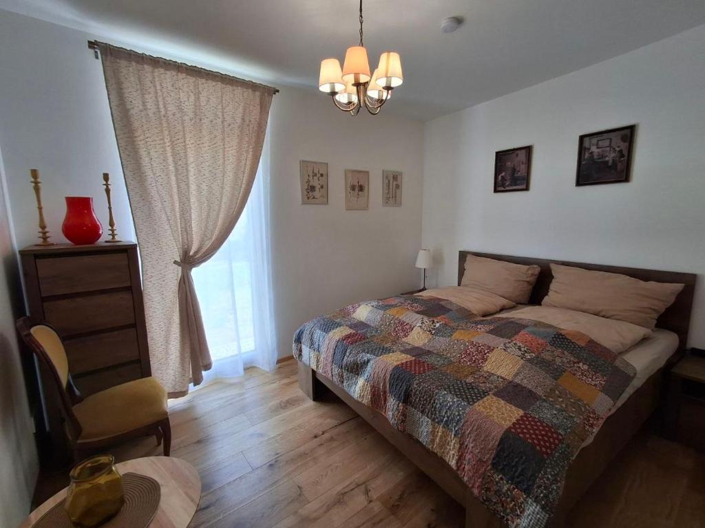 a bedroom with a bed and a chair and a window at Moderne Sauerhof Apartments in Baden