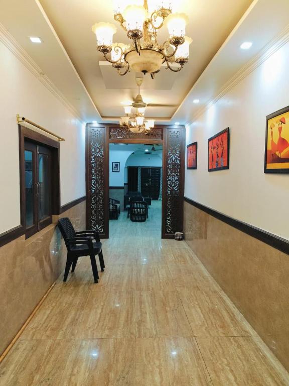 a lobby with a chandelier and a chair in a room at Green Haven Farm & Events in Bhundsi