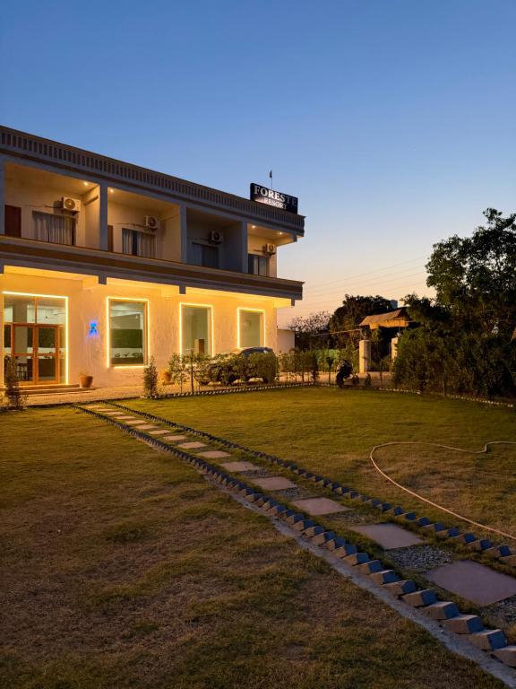 a house with a stone path in front of it at Foreste Resort in Rāmnagar