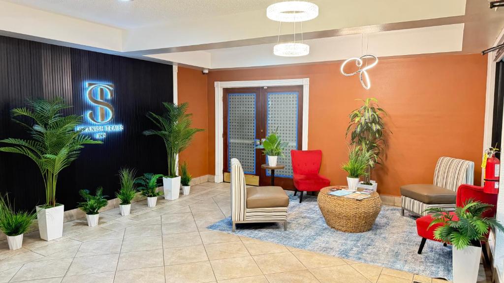 a lobby with plants and a sign on the wall at Spanish Trails Inn - Laredo Hotel in Laredo