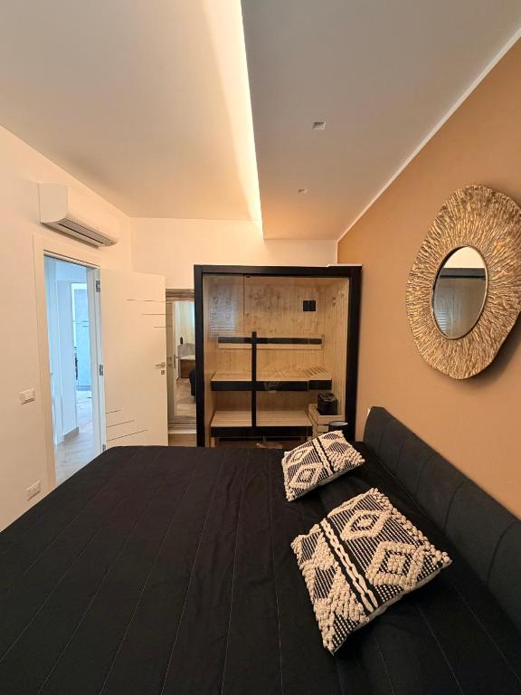 a bedroom with a black bed and a mirror at Las Palomas in Santa Flavia