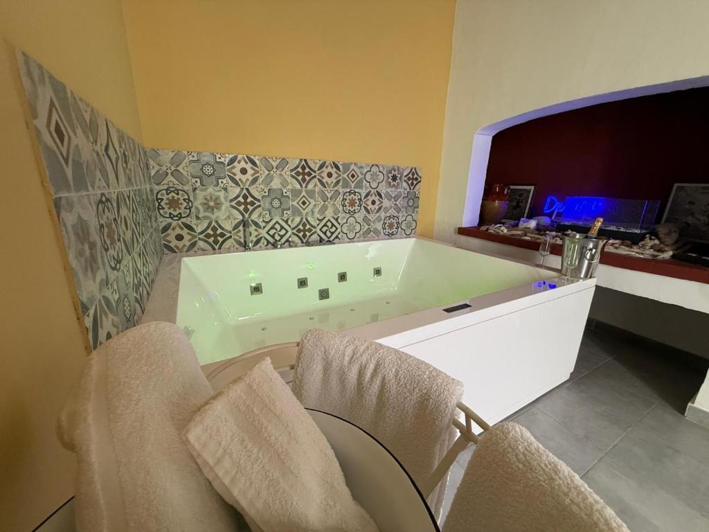 a bathroom with a tub and two chairs in it at Aquarius Salento in Acquarica del Capo