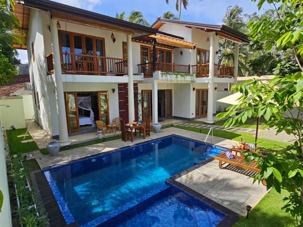 a villa with a swimming pool in front of a house at The Blacksmith Villa in Habaraduwa Central