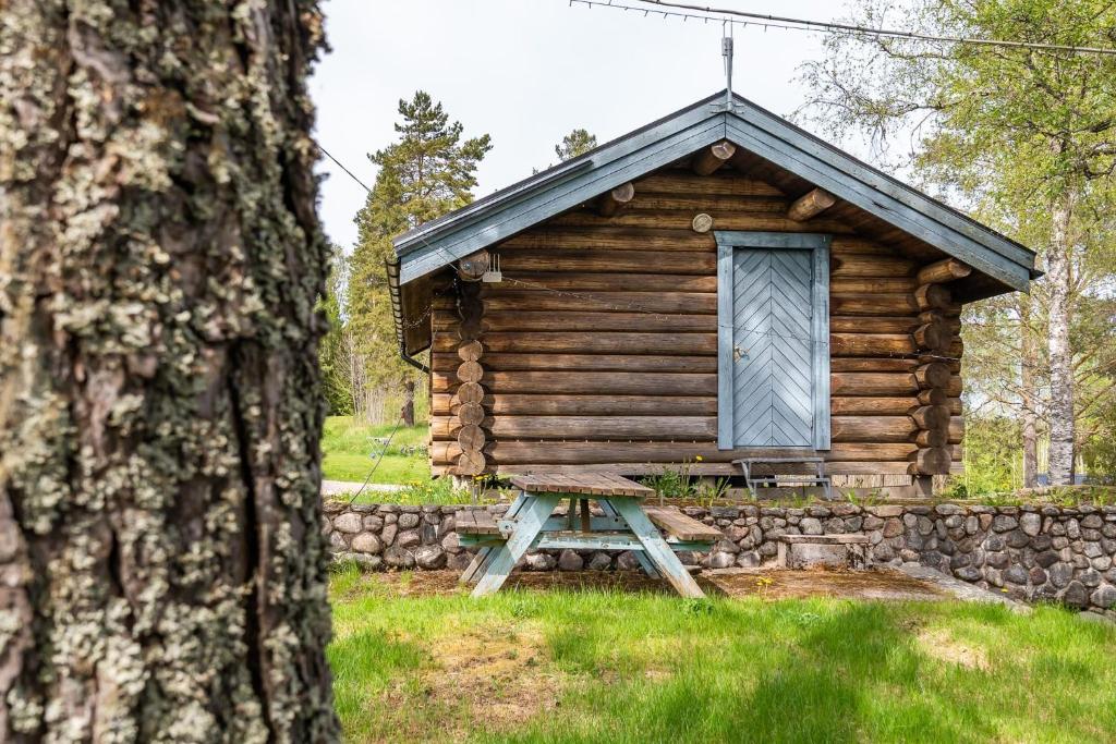 a log cabin with a table in front of it at Midsommar Stuga in Årjäng