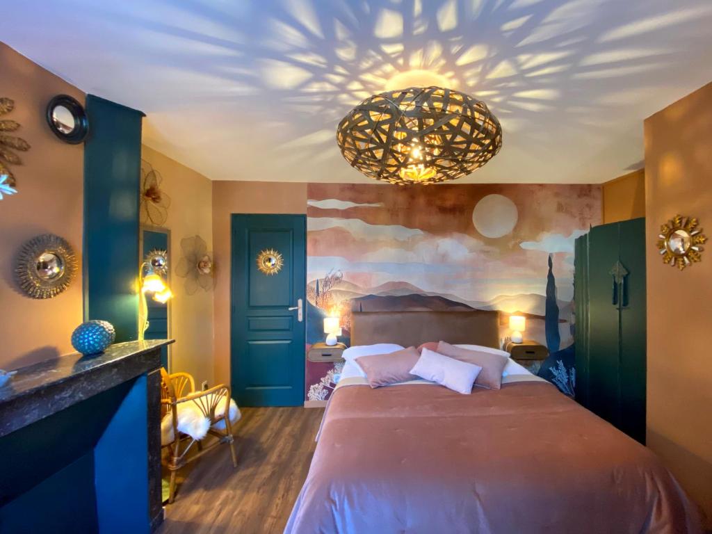 a bedroom with a large bed and a chandelier at BENE A CASA Chambres d'hôtes in Veuzain-sur-Loire