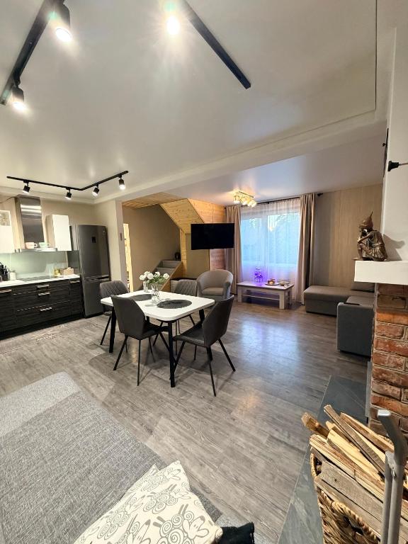 a living room with a table and chairs and a kitchen at Alexandra Forest Lake House in Konsu