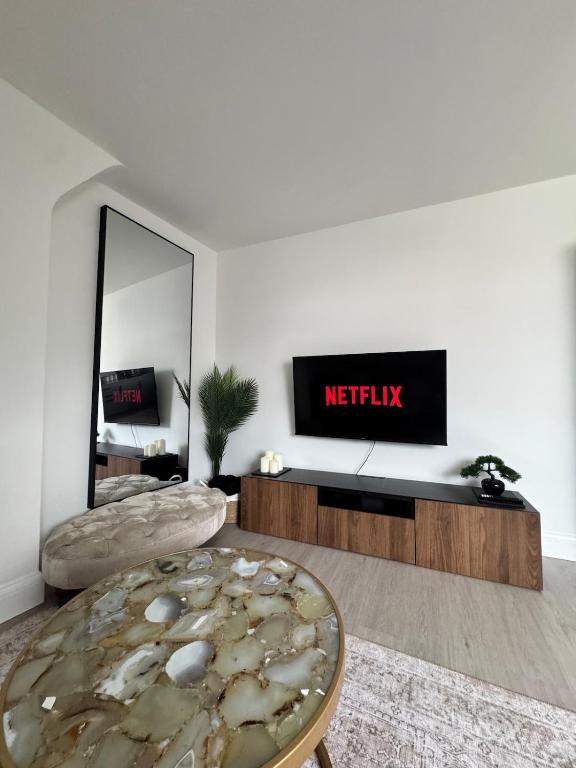 a living room with a tv and a table at Ultra cozy in Brookmans Park