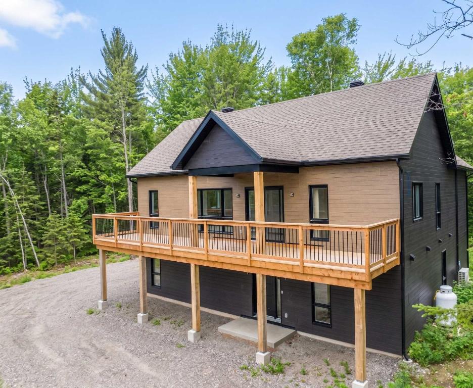 a house with a deck on the side of it at Spa Pool Table & Comfort - Chalet le Barista in Brownsburg