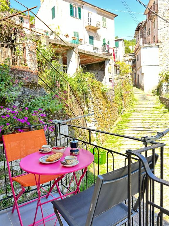 a pink table with plates of food on a balcony at Àa da Pinèla-Biassa-Cinque Terre in Biassa