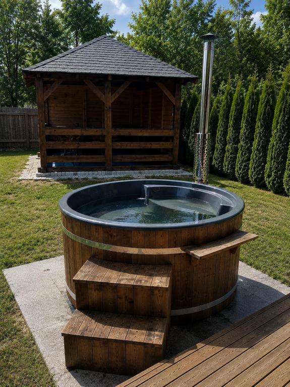 a hot tub in front of a wooden gazebo at Krasnobród Dom Całoroczny in Krasnobród