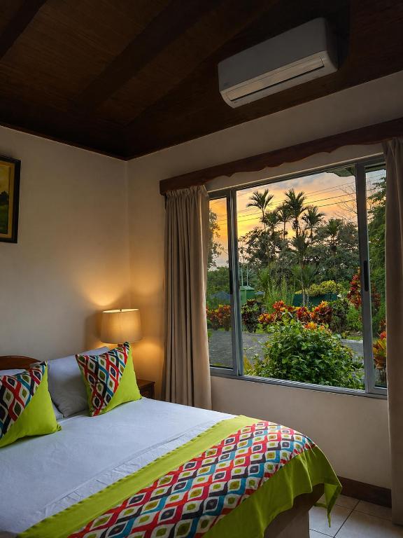 a bedroom with a bed and a large window at Hotel Villas Vilma in Fortuna