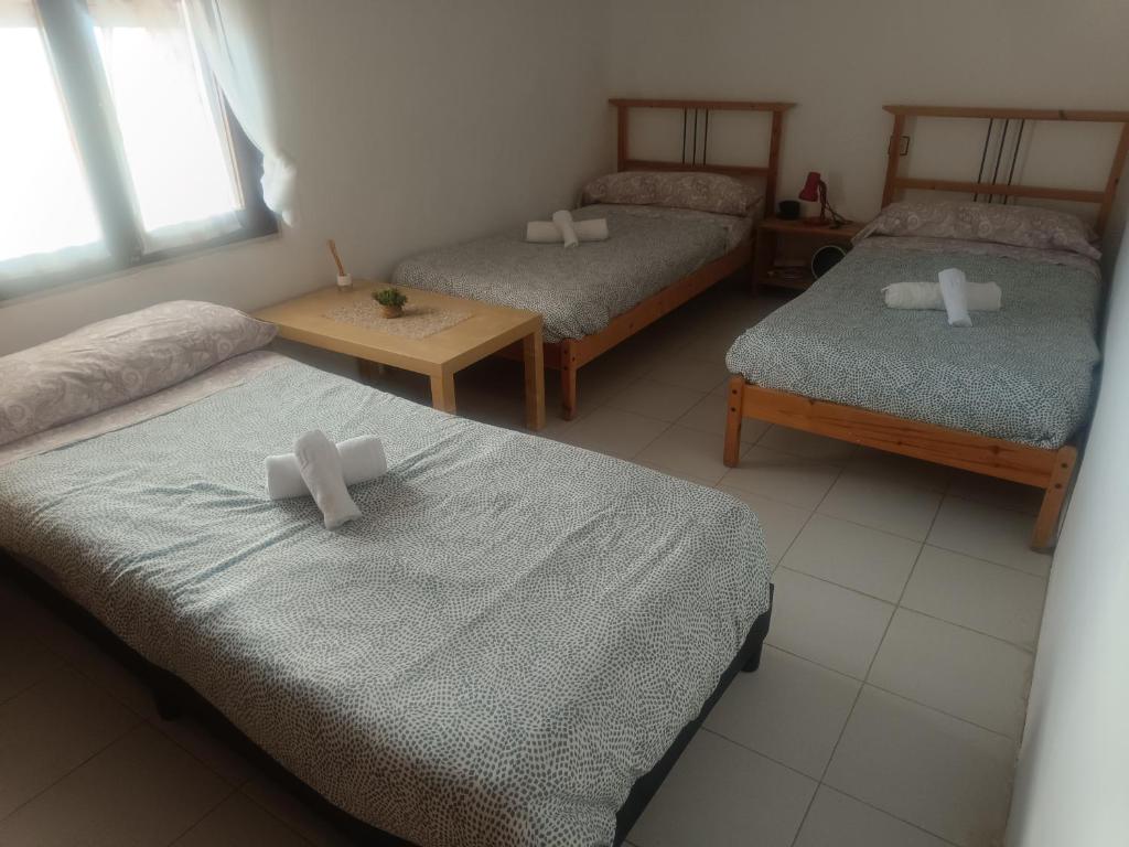 a room with three beds with white bows on them at Guara-Altaoja-Yaso in Yaso