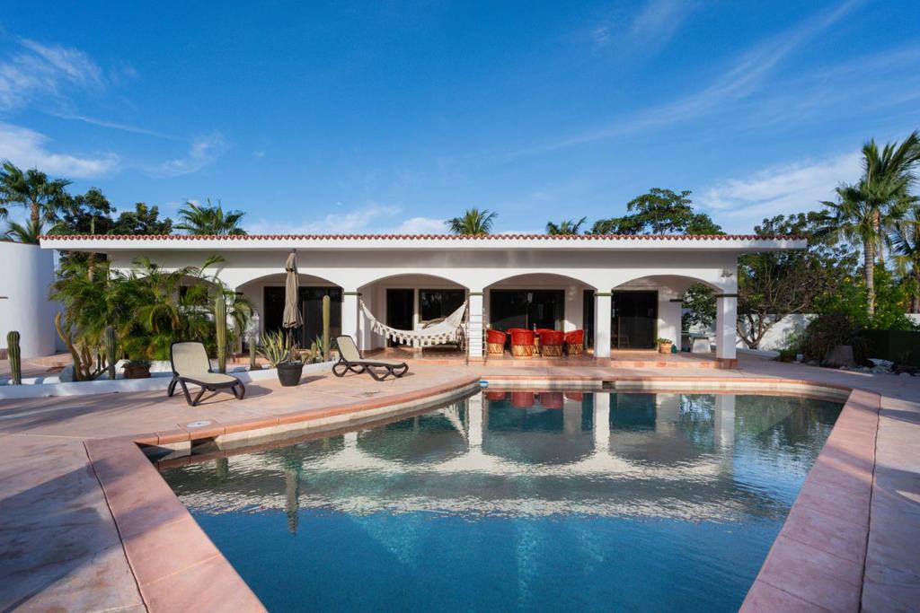 a house with a swimming pool in front of a house at Pool Oasis Close to the Beach and Pickleball in Las Palmas