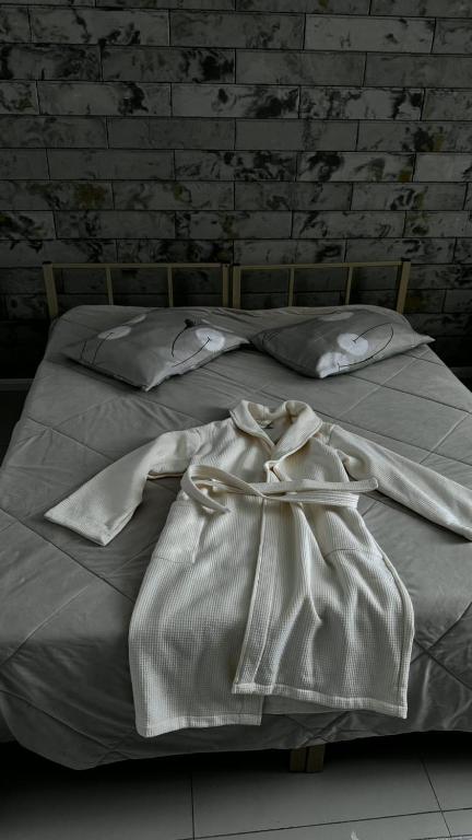 a white bed with a bow on top of it at Эталон АПАРТ-ОТЕЛЬ Aqtobе in Aktobe