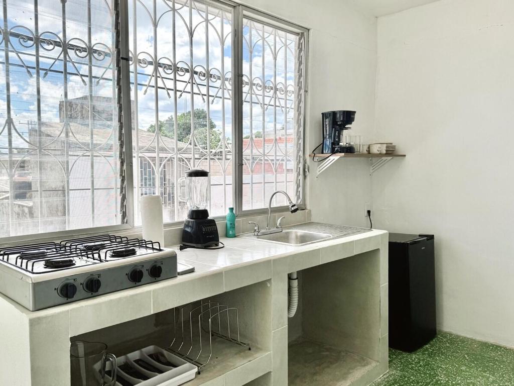 a kitchen with a stove and a sink and a window at Casona Tulish, Campeche in Campeche