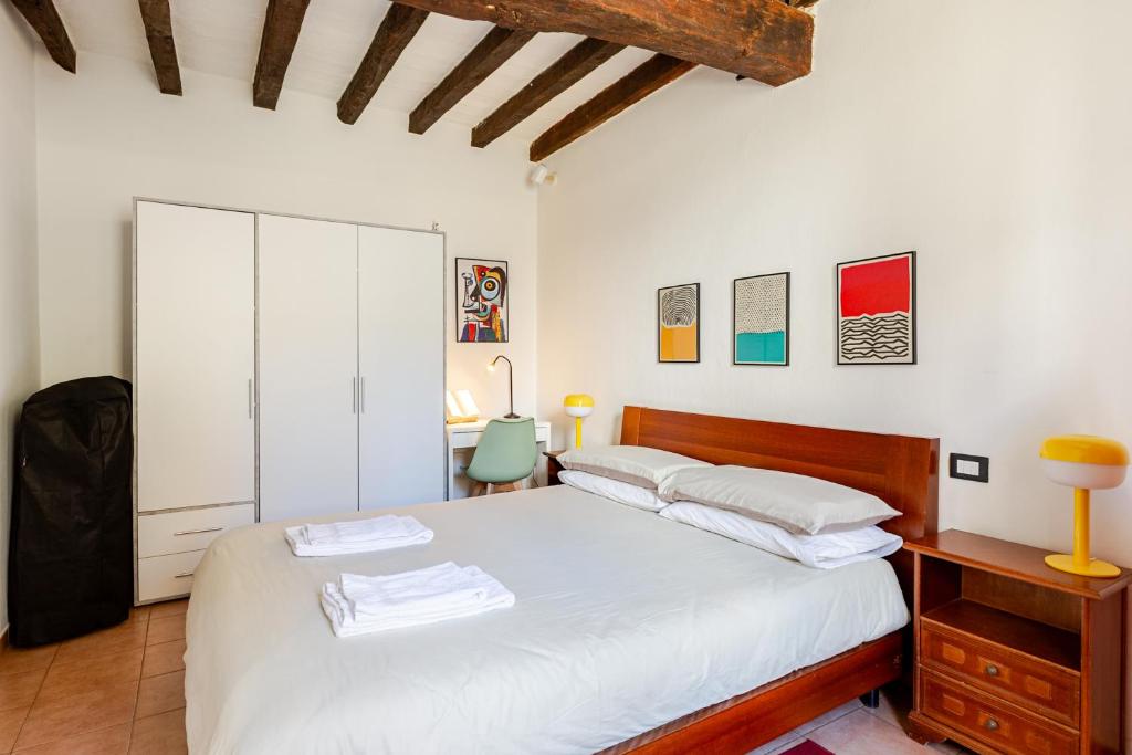 a bedroom with a white bed and a desk at Dimora Pia in Piacenza